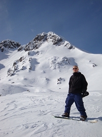 © Simon Welebil Stephan Kondert auf seinem Snowboard vor einem tiefverschneiten Berg bei traumhaftem Wetter